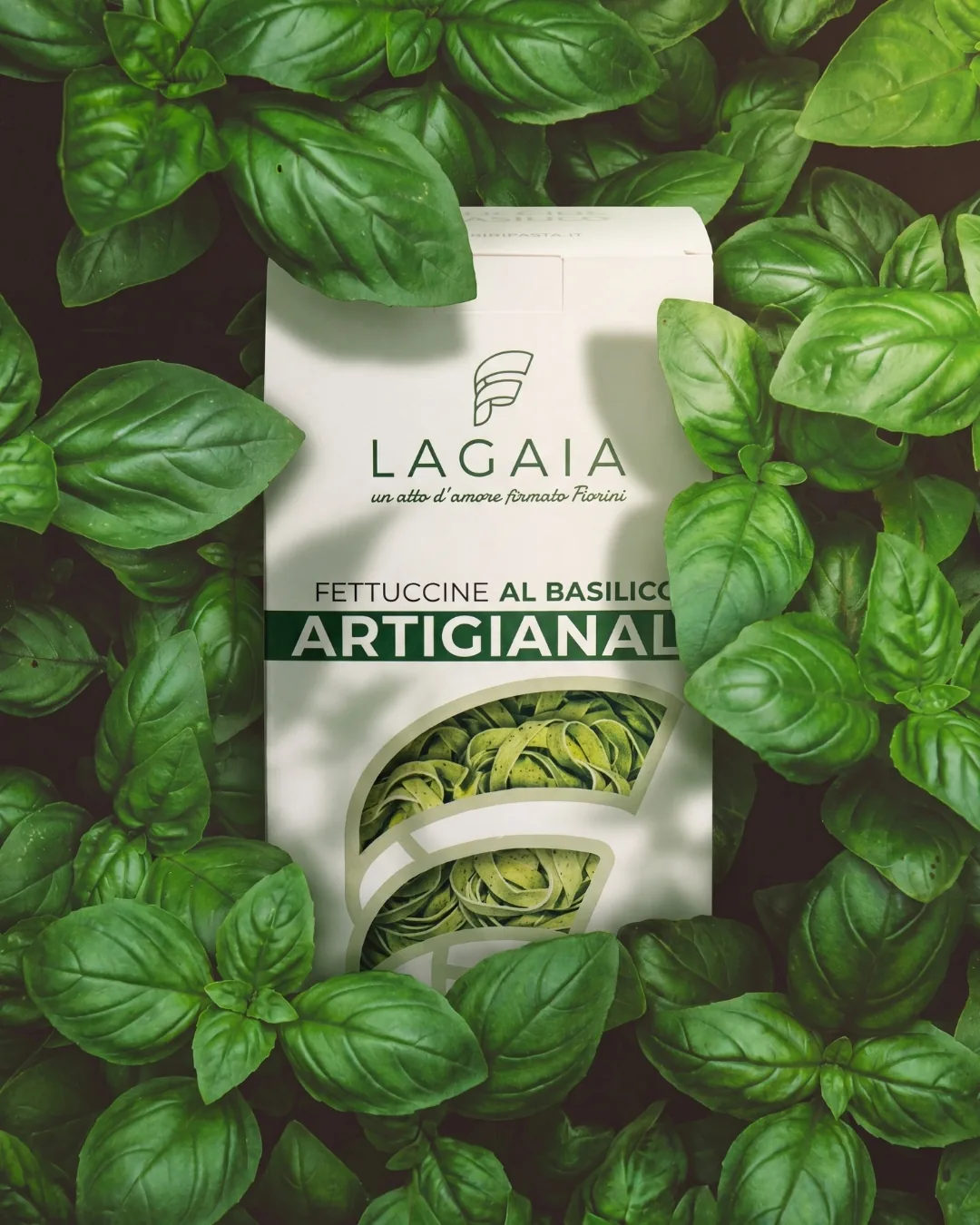 Confezione di fettuccine al basilico Lagaia appoggiata su un letto di foglie di basilico